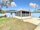 Cute blue house with a screened-in sunroom at 1447 Santa Anna Dr, Dunedin, FL 34698