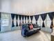 Sunroom with blue couch, game table, and dark blue curtains at 1447 Santa Anna Dr, Dunedin, FL 34698