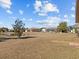 Backyard view showing a spacious lawn and pond in the background at 2309 Cross Tee Ct, Brooksville, FL 34604