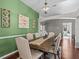 Dining room with a wood table, neutral chairs, and green accent wall at 2309 Cross Tee Ct, Brooksville, FL 34604
