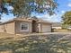 One-story house with a two-car garage, partially shaded by a tree at 2309 Cross Tee Ct, Brooksville, FL 34604