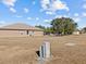 Rear view of house showing a tan exterior and grassy area at 2309 Cross Tee Ct, Brooksville, FL 34604
