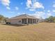 Tan house with a screened-in back porch and a large backyard at 2309 Cross Tee Ct, Brooksville, FL 34604