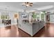 Open living room with gray sectional sofa, wood floors, and a large TV at 2309 Cross Tee Ct, Brooksville, FL 34604