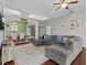 Comfortable living room featuring a gray sectional and wood flooring at 2309 Cross Tee Ct, Brooksville, FL 34604