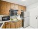 Galley kitchen with wood cabinets and appliances at 2700 Bayshore Blvd # 1305, Dunedin, FL 34698