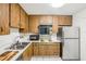Galley kitchen with wood cabinets and appliances at 2700 Bayshore Blvd # 1305, Dunedin, FL 34698