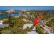 A high-angle captures a serene neighborhood with its charming homes, palm trees, and glimpses of the waterway at 3110 W De Bazan Ave, St Pete Beach, FL 33706