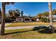 Charming single-story home featuring a well-manicured lawn, mature palm trees, and a covered carport at 3110 W De Bazan Ave, St Pete Beach, FL 33706