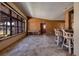 Open living area features large windows, tile floors, and wood-paneled walls at 3110 W De Bazan Ave, St Pete Beach, FL 33706