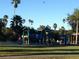Brightly colored playground with jungle gym and slides surrounded by a grassy field at 3110 W De Bazan Ave, St Pete Beach, FL 33706