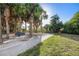 Scenic view of lush green lawn and concrete walking path with bench seating and tropical landscaping at 3110 W De Bazan Ave, St Pete Beach, FL 33706