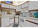 White kitchen with wood cabinets, microwave and oven at 3185 Charter Club Dr # A, Tarpon Springs, FL 34688