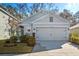 Gray house with a two-car garage and well-maintained landscaping at 32857 Brooks Hawk Ln, Wesley Chapel, FL 33543