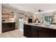 Open concept kitchen with island, granite countertops, and dark cabinets at 32857 Brooks Hawk Ln, Wesley Chapel, FL 33543