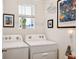 Bright laundry room with washer, dryer, and ample storage at 32857 Brooks Hawk Ln, Wesley Chapel, FL 33543