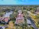 Aerial view of a townhouse community near a lake, showcasing Spanish-style architecture at 3505 Tarpon Woods Blvd # N404, Palm Harbor, FL 34685