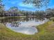 Community lakefront view with lush landscaping and townhouses at 3505 Tarpon Woods Blvd # N404, Palm Harbor, FL 34685