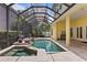 Relaxing pool and spa with screened enclosure, water features, and tile deck at 4023 W Horatio St, Tampa, FL 33609