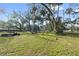 Large backyard with mature trees and grassy area at 405 Chastain Rd, Seffner, FL 33584