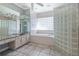 Bathroom with a large bathtub, glass block wall and double vanity at 405 Chastain Rd, Seffner, FL 33584