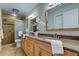 Bathroom with double sinks, wood cabinets, and a large shower at 4175 104 N Ave, Clearwater, FL 33762