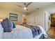 Spacious bedroom with a queen bed, ensuite bathroom access, and ceiling fan at 4175 104 N Ave, Clearwater, FL 33762