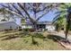 Quaint house nestled on a grassy lot, shaded by a large oak tree at 4175 104 N Ave, Clearwater, FL 33762