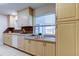 Well-lit kitchen featuring light wood cabinets and a window overlooking the backyard at 4175 104 N Ave, Clearwater, FL 33762