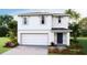 Two-story house featuring a white exterior, two-car garage, and landscaping at 5247 Salt Marsh Rd, Wimauma, FL 33598