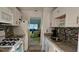 Galley kitchen with granite countertops and white cabinets at 5975 Terrace Park N Dr # 102, St Petersburg, FL 33709