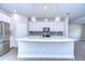 Modern kitchen with white cabinets, quartz island, and pendant lighting at 6112 Plover Meadow St, Lithia, FL 33547