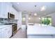 Modern kitchen with white cabinets, quartz countertops, and stainless steel appliances at 6112 Plover Meadow St, Lithia, FL 33547