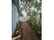 Brick pathway meanders through a lush, landscaped side yard at 7711 Innis Ct, St Petersburg, FL 33709