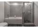 Bathroom with tub, shower, and gray tile at 1010 Central Ave # 106, St Petersburg, FL 33705