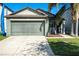 House exterior featuring a green garage door and palm tree at 12720 Hampton Hill Dr, Riverview, FL 33578