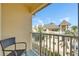 Relaxing condo balcony with wicker chair, offering a view of surrounding buildings at 17960 Gulf Blvd # 103, Redington Shores, FL 33708