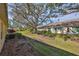 Landscaped backyard with mature trees and grassy area at 2405 New Haven Cir, Sun City Center, FL 33573