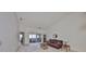 Living room with vaulted ceiling, brown leather couch, and view of lanai at 2405 New Haven Cir, Sun City Center, FL 33573