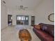 Living room with vaulted ceiling, brown leather couch, and view of lanai at 2405 New Haven Cir, Sun City Center, FL 33573