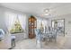 Dining area featuring a glass table, tropical chairs, large windows, and a decorative display cabinet at 2468 Florentine Way # 52, Clearwater, FL 33763