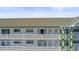 Condo building featuring a white exterior with green trim and decorative railings on multiple levels at 2468 Florentine Way # 52, Clearwater, FL 33763