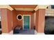 Building entryway featuring a teal door, stone walkway, and a bench at 2757 Via Cipriani # 1114A, Clearwater, FL 33764