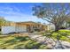 Tan single story home with a red door and driveway at 2765 57Th N St, St Petersburg, FL 33710