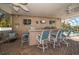 Outdoor kitchen with bar seating and a view of the pool at 3998 South Cir, Largo, FL 33774