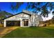 Modern home with a circular design, two-car garage, and manicured lawn at 5526 Southernview Dr, Zephyrhills, FL 33541