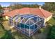 Aerial view of a screened pool with an attached home and well-maintained landscaping at 9223 Highland Ridge Way, Tampa, FL 33647