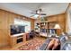Home office with wood-paneled walls, built-in shelves, and comfortable seating at 10020 Kenda Dr, Riverview, FL 33578