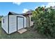 White storage shed with a wooden ramp at 10020 Kenda Dr, Riverview, FL 33578