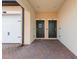 Front entry of townhouses featuring two dark green doors and brick pavers at 10043 Crooked Creek Dr # 202, Venice, FL 34293
